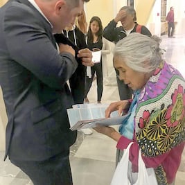 Doña Gloria le regala cachitos de lotería al empresario Alfredo Harp