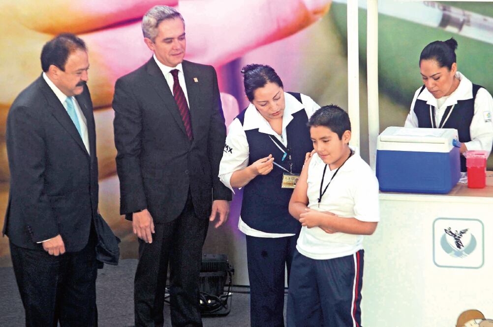 Miguel Mancera, durante la aplicación de la vacuna contra el virus del Papiloma Humano en una primaria en Isabel la Católica (FERNANDO RAMÍREZ. EL UNIVERSAL)