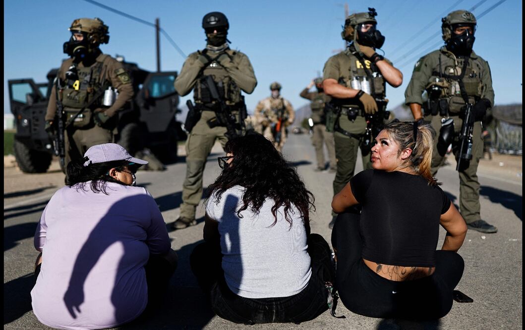 Mujeres realizan una sentada frente al avance de agentes federales durante una redada de inmigración del ICE en una granja de cannabis con licencia cerca de Camarillo, California, el 10 de julio de 2025. Foto: AFP