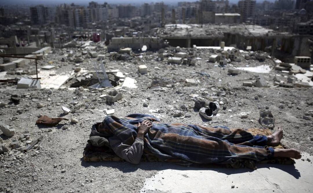 Un hombre descansa entre los escombros de un edificio en el barrio de Barzeh en Damasco (Foto: EFE)