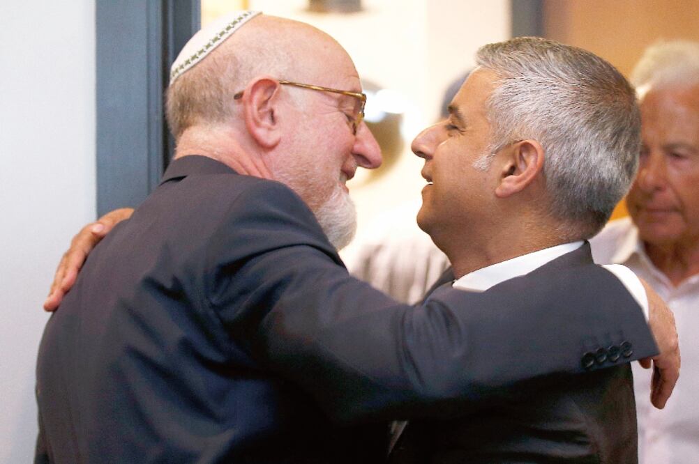 Sadiq Khan (der.) es felicitado por Henry Grunwald, al arribar a la ceremonia de conmemoración del Holocausto que se llevó a cabo ayer, en Londres (PETER NICHOLLS. REUTERS)