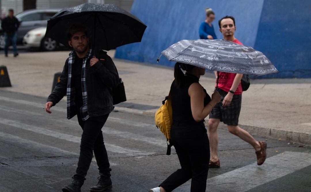 Los capitalinos comenzaron a usar sus paraguas, ponchos y bolsas para atajarse de la lluvia que comenzó a caer en calles del centro histórico. Foto: Francisco Rodríguez