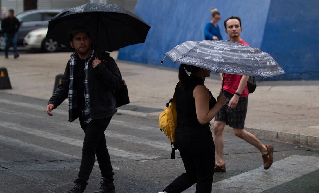 Los capitalinos comenzaron a usar sus paraguas, ponchos y bolsas para atajarse de la lluvia que comenzó a caer en calles del centro histórico. Foto: Francisco Rodríguez