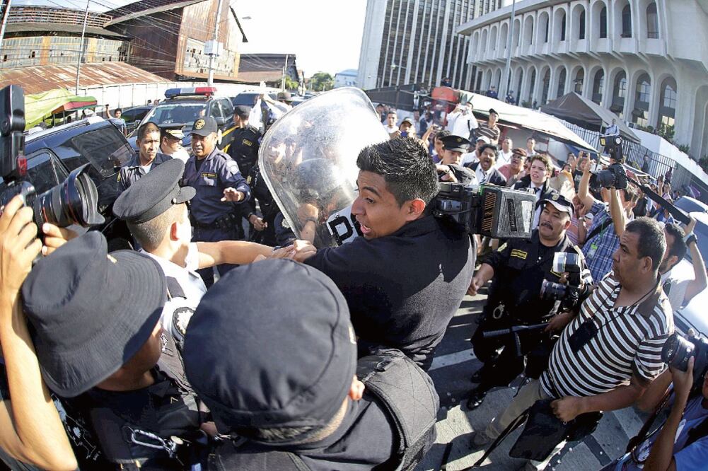 Policías antimotines guatemaltecos enfrentan a los medios, que intentan tomar fotos y videos de la ex vicepresidenta Roxana Baldetti, quien ayer quedó bajo prisión preventiva, en el caso de corrupción de “La Línea” (JORGE DAN LÓPEZ. REUTERS)
