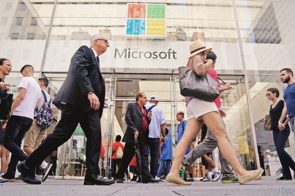 Transeúntes pasan frente a una tienda de Microsoft en Nueva York. La empresa tecnológica informó que desactivó seis páginas creadas por hackers rusos. (CARLO ALLEGRI. REUTERS)