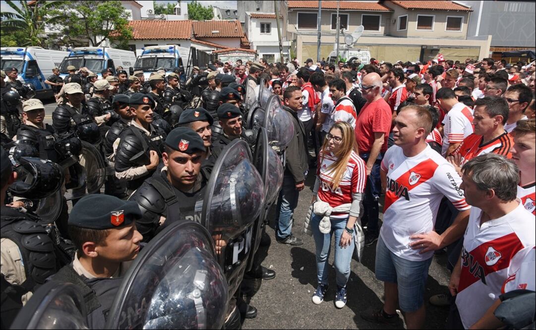 Elementos de seguridad junto a aficionados de River Plate. Foto: AFP