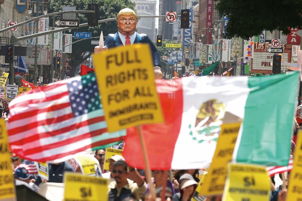 Una multitud marchó el 1 de mayo pasado en Los Ángeles, California, en favor de los derechos de los inmigrantes, con un muñeco gigante de Donald Trump sosteniendo una capucha del Ku Klux Klan, en alusión a su discurso xenófobo (LUCY NICHOLSON. REUTERS)