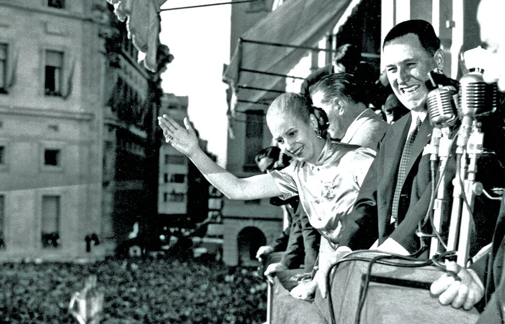 En esta imagen del 17 de octubre de 1950, la primera dama argentina, Eva Duarte de Perón, saluda desde el balcón de la Casa Rosada a la gente, mientras su esposo, el presidente Juan Perón, sonríe, durante el “Día de la Lealtad” (AP. ARCHIVO)