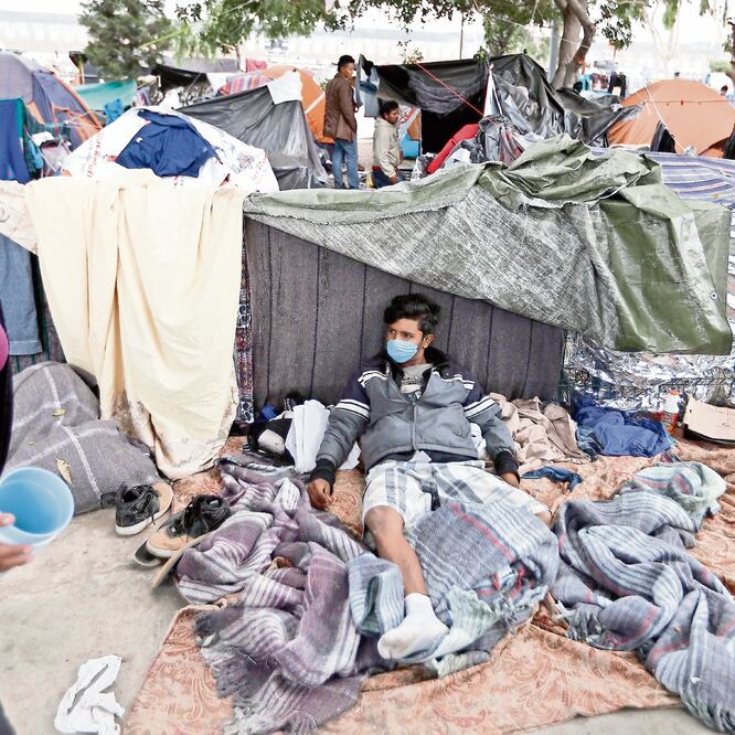 En espera. Ante la proliferación de enfermedades, migrantes utilizan mascarillas en el campamento de Tijuana, que ya rebasó su capacidad. Foto: REBECCA BLACKWELL. AP
