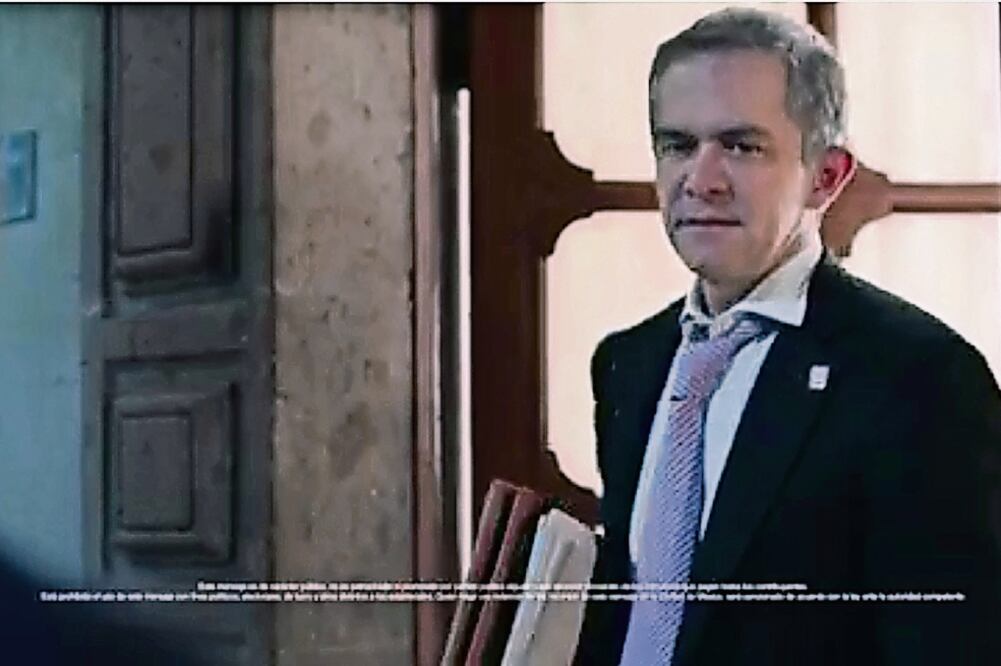 En el material de 27 segundos de duración se observa a una mujer trapeando en el Palacio del Ayuntamiento cuando sale Mancera, con la corbata floja y los botones de la camisa desabrochados, le da las buenas noches y se retira (TOMADA DEL VIDEO))