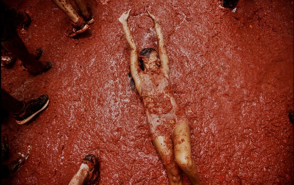 Una mujer reacciona mientras participantes se lanzan tomates durante la Tomatina, el miércoles 27 de agosto de 2025. Foto: AP