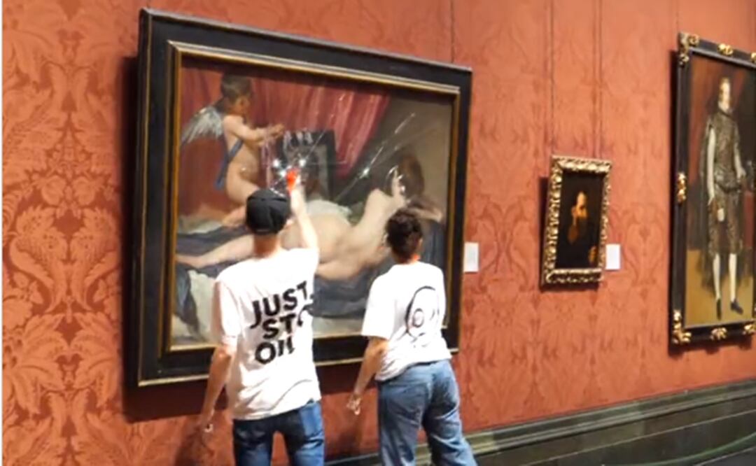 Los dos activistas de Just Stop Oil, dando martillazos al cuadro 'La venus del Espejo', de Velázquez. Foto: Tomada del video