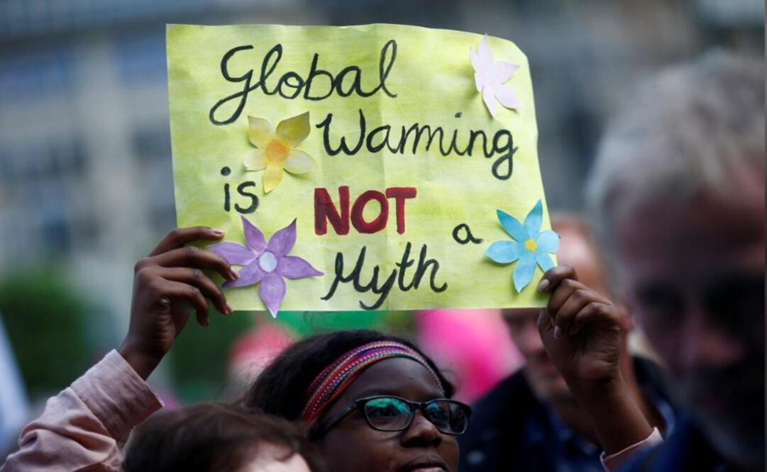 People take part in protests in Hamburg, Germany. Placard reads "Global Warming is NOT a Myth" - Photo: Hannibal Hanschke/REUTERS