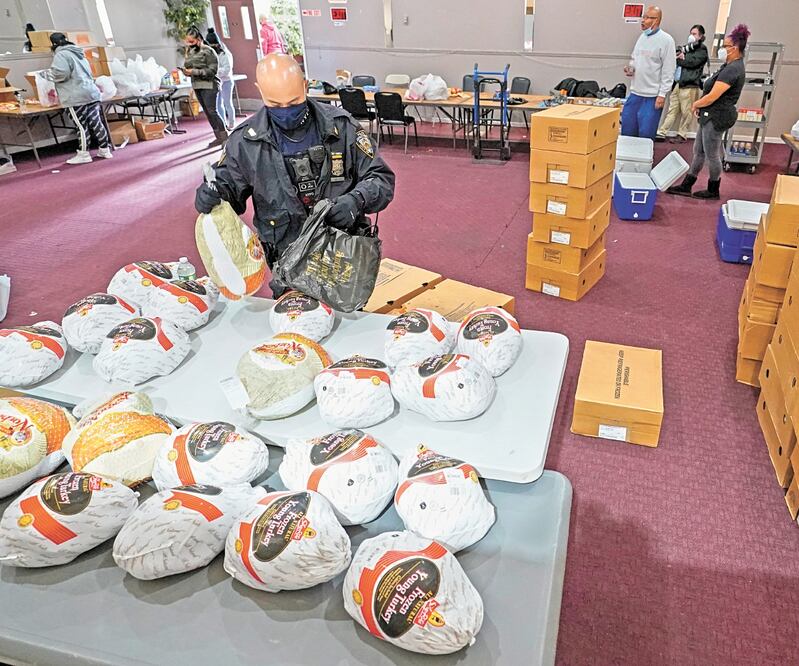 Un policía de Nueva York, ayer durante la distribución de alimentos por el Día de Acción de Gracias en el centro familiar Life Center, en Staten Island. Foto: MARY ALTAFFER. AP