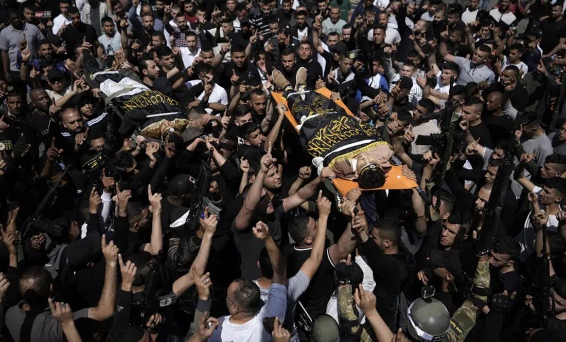 Una multitud traslada los cadáveres de Ahmed Assaf, de 19 años, y Rani Qatanat, de 24, envueltos en la bandera del grupo Yihad Islámica, dos palestinos asesinados por las fuerzas israelíes en Qabatiya, cerca de la ciudad cisjordana de Yenín. Foto: AP