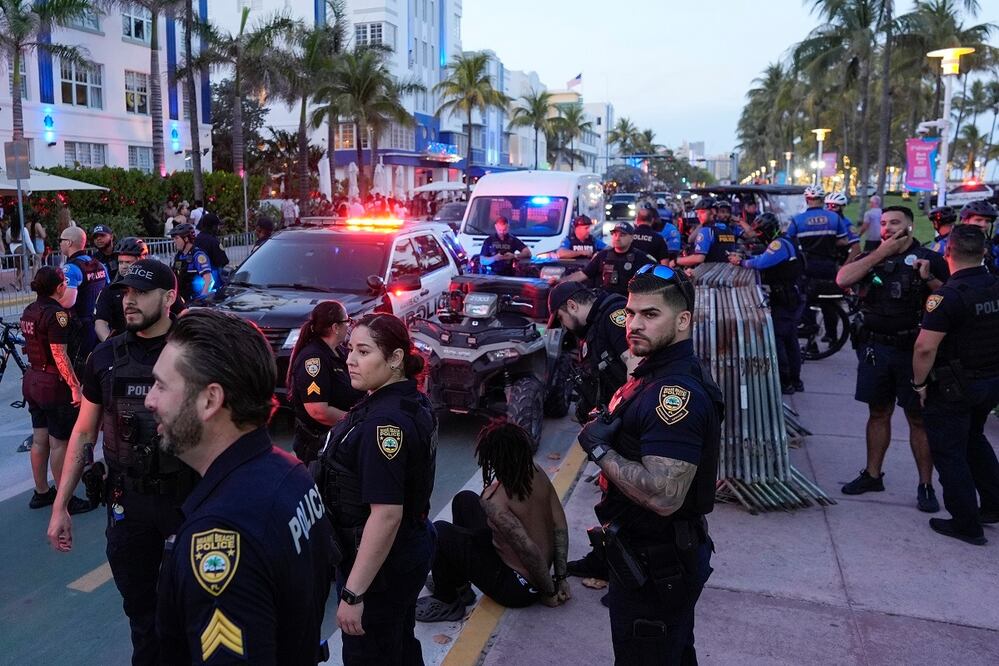 Un hombre es esposado temporalmente mientras la policía, presente en masa a lo largo de Ocean Drive como medida disuasoria durante las vacaciones de lo spring breakers, responde a un incidente, en Miami Beach, Florida. Foto: AP