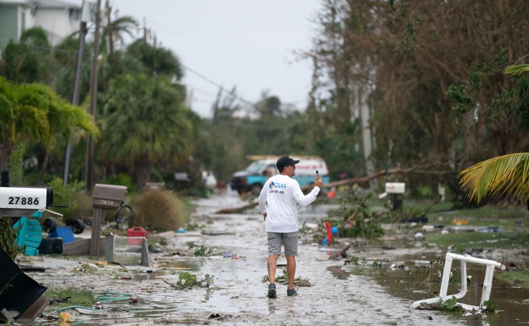 Un hombre documenta los daños causados por la tormenta con su teléfono después del huracán en Bonita Springs. Foto: AFP