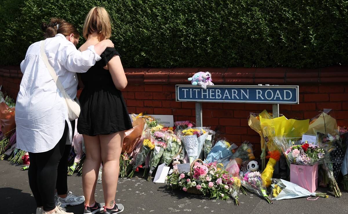 Gente mira los homenajes dejados en la escena de un ataque con puñaladas en el cruce con Hart Street en Southport, Gran Bretaña. Foto: EFE