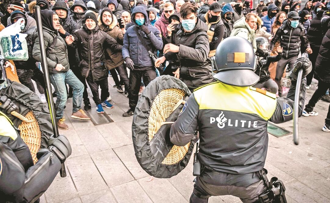 La policía se enfrentó ayer a manifestantes en la plaza 18 de Septiembre en Eindhoven, en Países Bajos. Cientos participaron en una protesta contra las medidas de confinamiento por la pandemia de coronavirus. Foto: Rob Engelaar. EFE