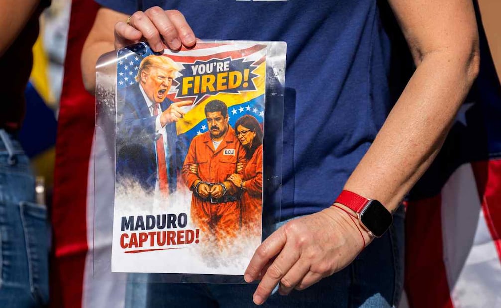 Una mujer sostiene una imagen del presidente de Estados Unidos, Donald Trump, el presidente de Venezuela, Nicolás Maduro, y su esposa, Cilia Flores, en el estacionamiento de Mi Querencia Latin Market cerca de Westheimer Parkway en Katy, Texas, el sábado 3 de enero de 2026 / Foto: Jason Fochtman/Houston Chronicle via AP