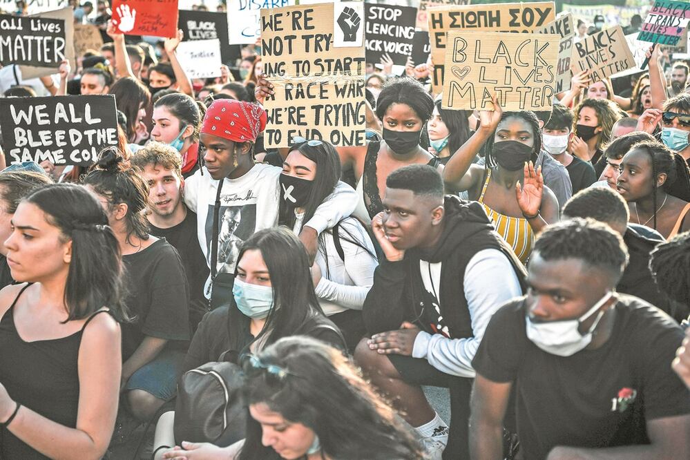 Jóvenes protestaron ayer en Atenas, Grecia, frente a agentes antidisturbios contra el racismo, la brutalidad policial y en apoyo a las movilizaciones en Estados Unidos por el asesinato de George Floyd. Foto: LOUISA GOULIAMAKI. AFP
