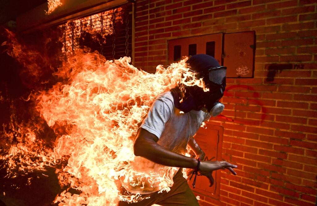 El fotoperiodista venezolano Ronaldo Schemidt recibió hoy en Amsterdam el premio World Press Photo por una imagen que retrata la quema accidental de un manifestante de la oposición durante unos disturbios en Caracas, en mayo de 2017.  Foto AP