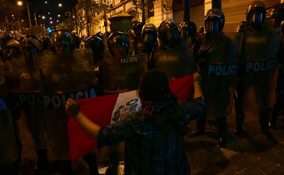 Un simpatizante del expresidente Pedro Castillo grita a la policía antidisturbios mientras sostiene una bandera durante una protesta. Foto: AFP