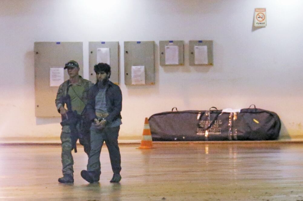 Un policía federal de Brasil trasladó a un sospechoso por cargos relacionados con terrorismo, el 21 de julio de 2016. De acuerdo con las autoridades prometió lealtad el Estado Islámico (ERALDO PERES. AP)