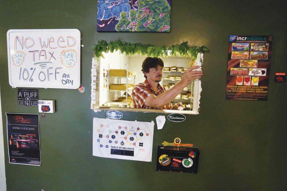 David Shepard prepara etiquetas exigidas por la ley con la fecha de venta de productos de marihuana para consumo recreativo, en la tienda The Grass Station, en Denver, Colorado. BRENNAN LINSLEY. AP