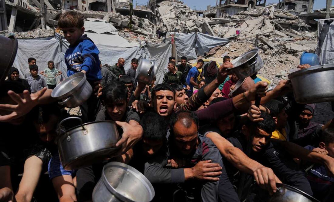 Palestinos luchan por conseguir alimentos donados en una cocina comunitaria en Beit Lahia, al norte de la Franja de Gaza, el 3 de mayo de 2025. Foto: AP
