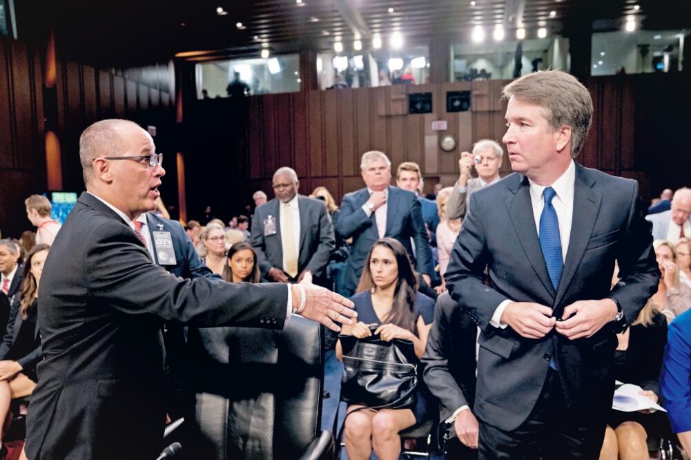 El padre de una víctima del tiroteo en Parkland, Florida (izq.) intenta saludar a Brett Kavanaugh (der), candidato del presidente de EU a la Suprema Corte. (ANDREW HARNIK. AP)