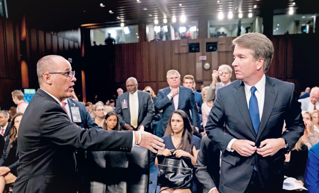 El padre de una víctima del tiroteo en Parkland, Florida (izq.) intenta saludar a Brett Kavanaugh (der), candidato del presidente de EU a la Suprema Corte. (ANDREW HARNIK. AP)