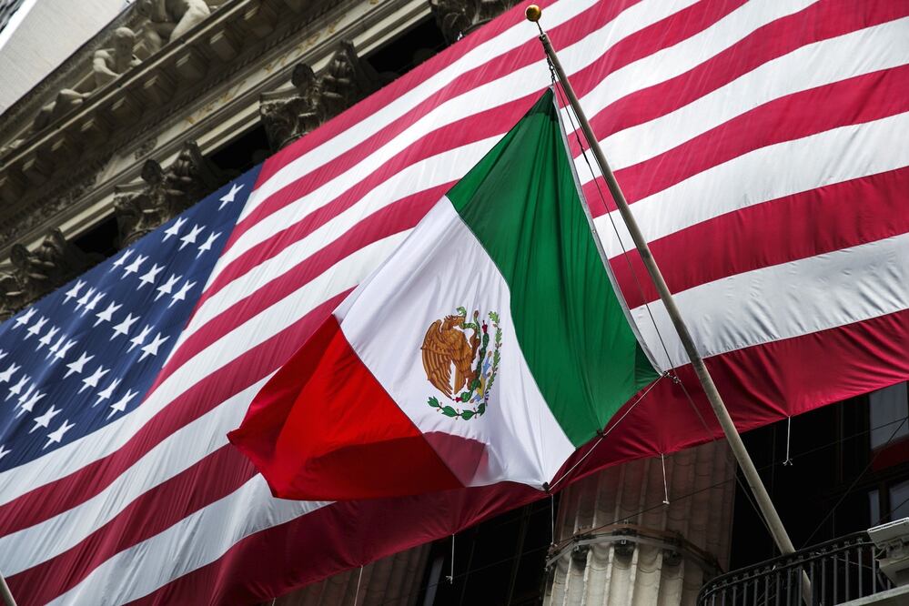 The flag of Mexico changes in front of a large U.S. flag in front of the New York Stock Exchange September 4, 2015. REUTERS/Lucas Jackson