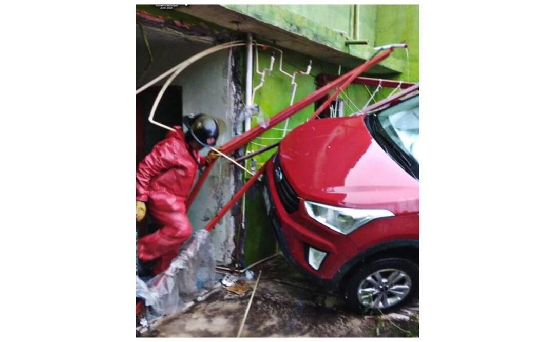 Bomberos de este municipio auxiliaron a habitantes luego de que un auto compacto color rojo fue arrastrado por la corriente y cayó al patio de una casa en la colonia Pueblo Viejo. Foto: Especial