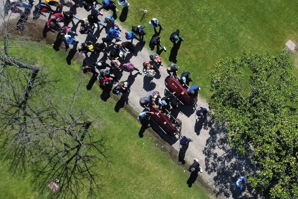 Fotografía aérea que muestra a los asistentes del funeral de Brenda del Castillo y Morena Verdi, víctimas de feminicidio, en el cementerio Las Praderas,  en Buenos Aires. FOTO: ADAN GONZÁLEZ. EFE