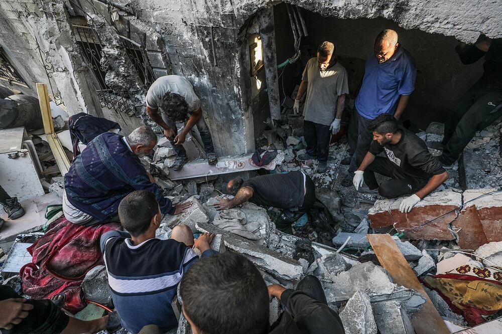 Palestinos buscan cadáveres y supervivientes entre los escombros de la casa destruida de la familia Al-Tilbany tras un ataque aéreo israelí en el campo de refugiados de Al-Maghazi en la Franja de Gaza. Foro: EFE