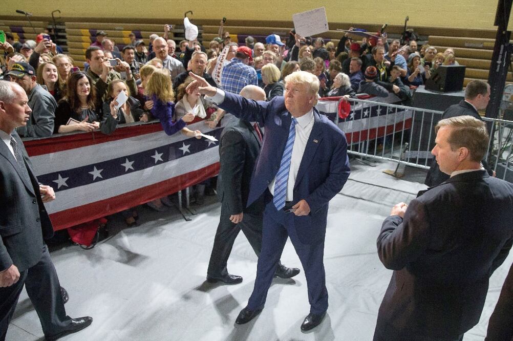 Trump saluda a sus simpatizantes, durante un acto de campaña realizado el domingo en la escuela Muscatine, en Iowa, donde el lunes próximo hay caucus (ANDREW HARNIK. AP)