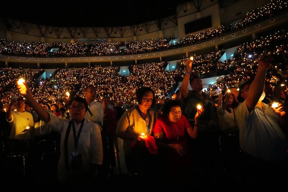 Personas sostienen velas eléctricas mientras cantan durante un servicio de Nochebuena en el estadio Indonesia Arena en Yakarta, Indonesia. Foto: AP