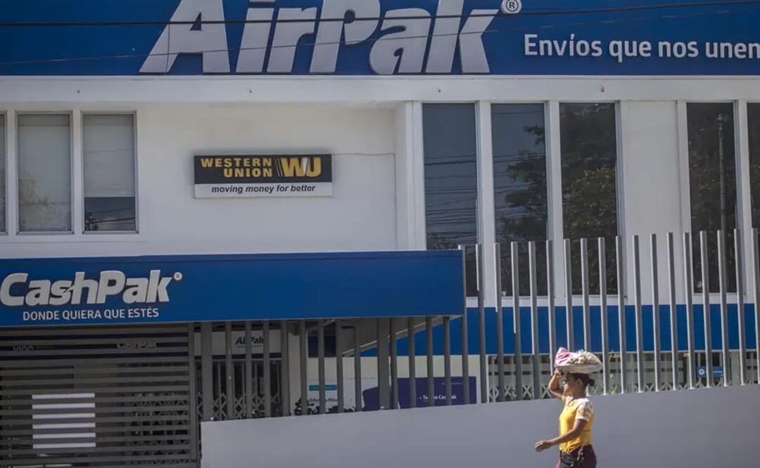 Una vendedora de dulces pasa por una rama de la Western Union en Managua, Nicaragua. Foto: AP 