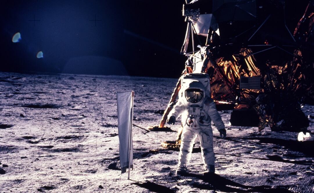 Astronaut Edwin E. Aldrin Jr. walks on the surface of the moon, with seismogaphic equipment that he just set up. The flag like object on a pole is a solar wind experiment and in the background is the Lunar Landing Module - Photo: Neil Armstrong/NASA