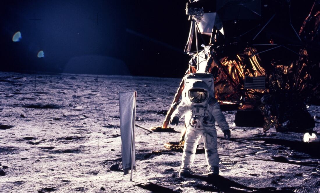 Astronaut Edwin E. Aldrin Jr. walks on the surface of the moon, with seismogaphic equipment that he just set up. The flag like object on a pole is a solar wind experiment and in the background is the Lunar Landing Module - Photo: Neil Armstrong/NASA