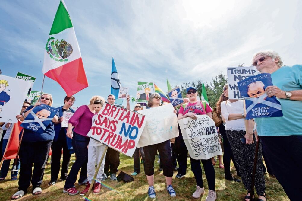 Un grupo de manifestantes expresa su rechazo al presidente de EU, Donald Trump, en los límites del campo de golf Trump Turnebrry, la propiedad que tiene el magnate cerca de Aberdeen, en Escocia . (MICHAL WACHUCIK. AFP)