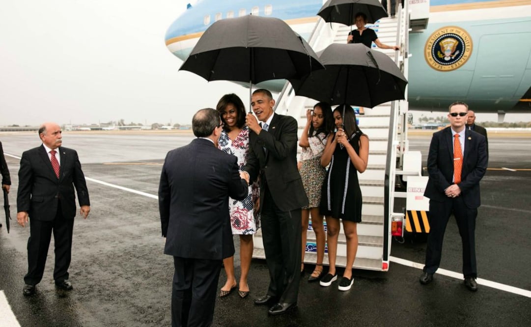 Otra de las fotos muestra a Obama sosteniendo un paraguas durante el fuerte aguacero caído el domingo en la capital cubana