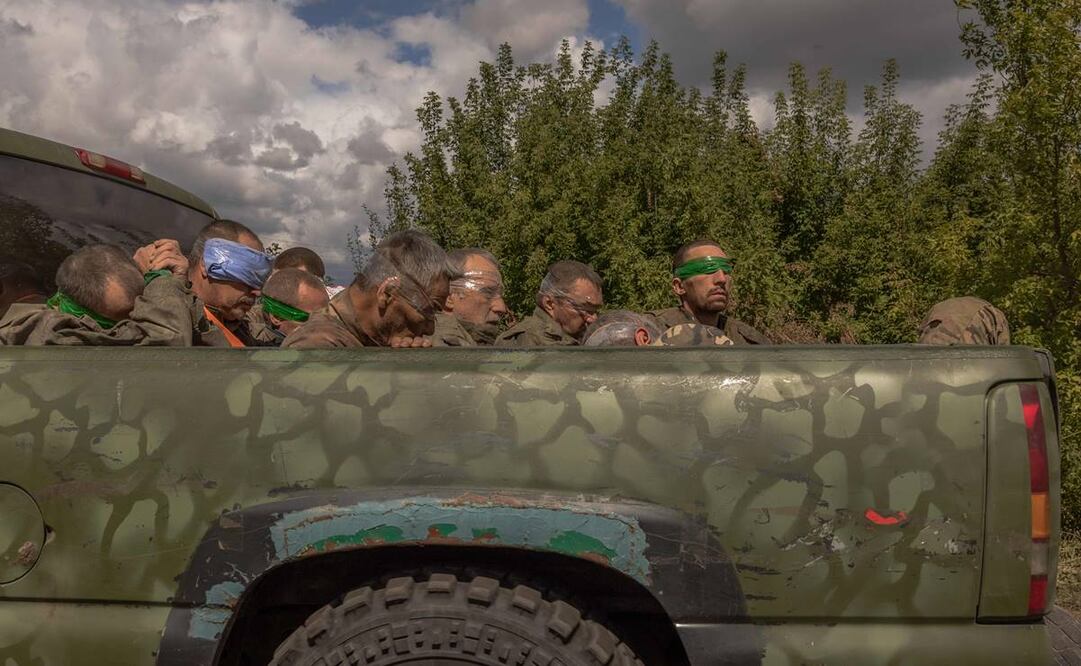 Un vehículo militar ucraniano conduce desde la frontera con Rusia llevando a hombres con los ojos vendados y vestidos con uniformes militares rusos. Foto: AFP