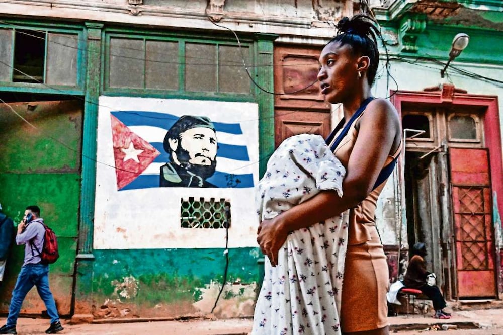 Una mujer caminando  durante un apagón en La Habana el 4 de marzo de 2026. Crédito: Yamil Lage / AFP