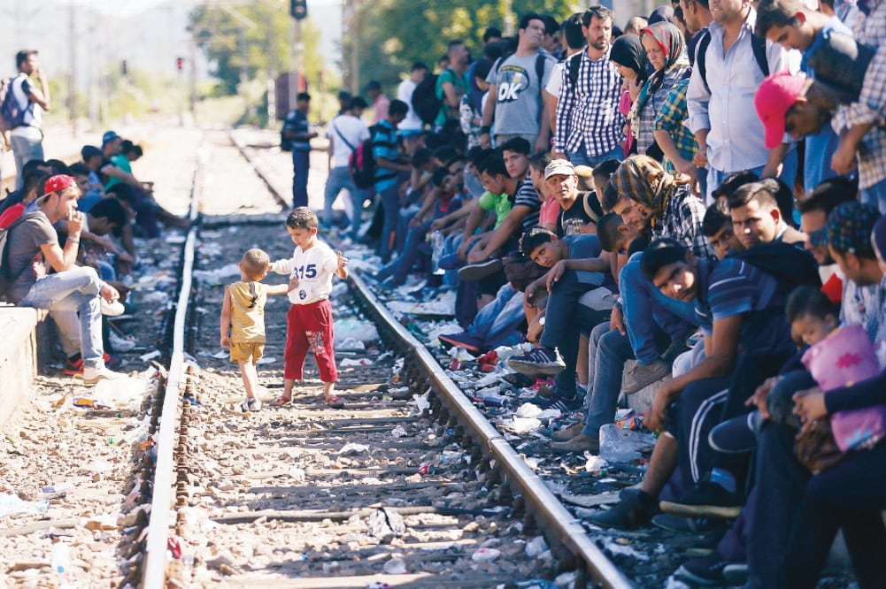 Migrantes de diversos países esperan un tren que los traslade a Serbia, en la estación de la localidad macedonia de Gevgelija (DARKO VOJINOVIC. AP)