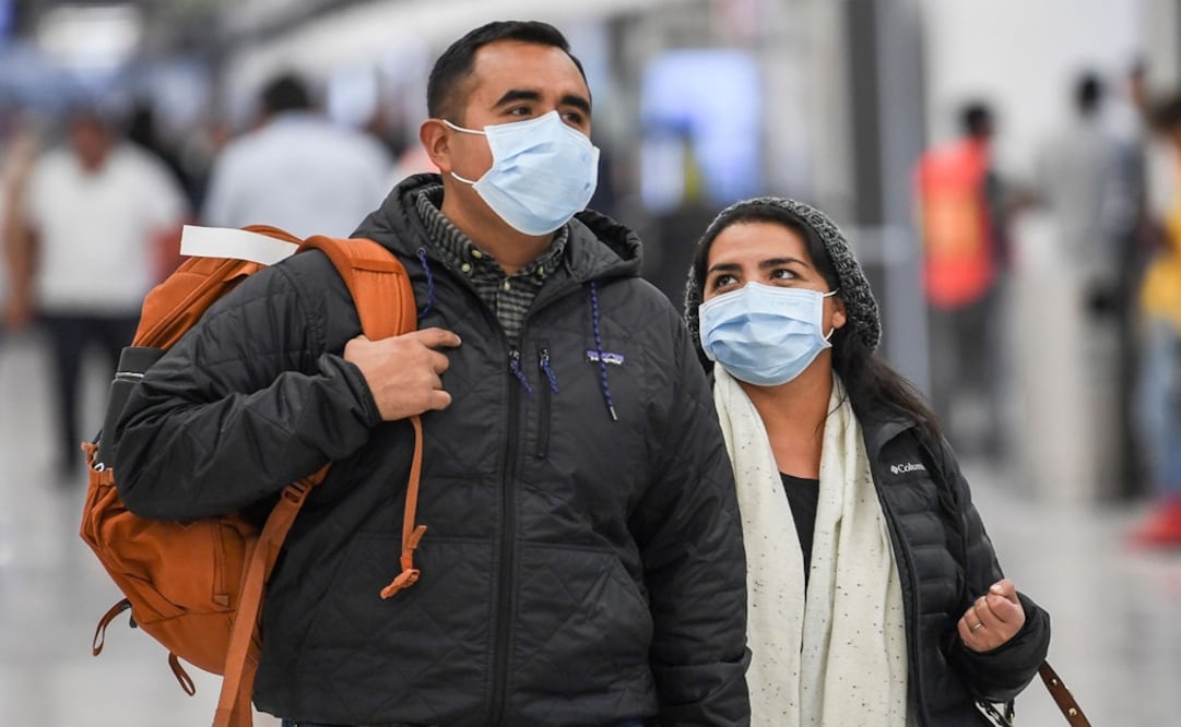 Passengers wear protective masks against the spread of coronavirus as they arrive at the Mexico City International Airport – Photo: Pedro Pardo/AFP