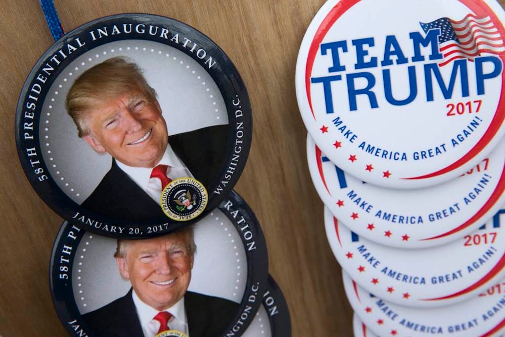 Comerciantes preparan la venta de chapas con la imagen del presidente electo Donald Trump. Foto: EFE