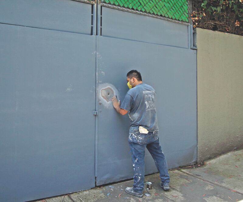 Un trabajador de una vivienda cercana al lugar del atentado resanó las marcas que dejaron los proyectiles de armas detonadas el viernes. Foto: CARLOS MEJÍA. EL UNIVERSAL