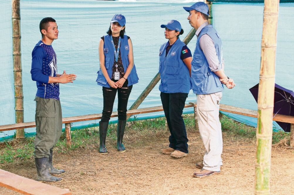 Los mexicanos (con gorra y chaleco, de izq. a der.) Oyuki Ang Anaya, civil; Cecilia Sáenz Morales, teniente de la Semar, y Jorge Alberto Gómez Muñoz, capitán de fragata de la misma secretaría, dialogan con un elemento de las FARC (HÉCTOR FABIO ZAMORA)